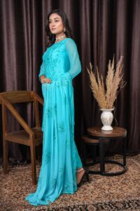 Fashion model in blue embroidered dress posing indoors. Elegant and stylish fashion photography.