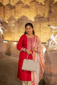 Woman in red traditional attire holding a handbag