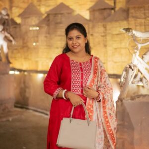 Woman in red traditional attire holding a handbag