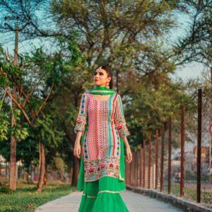 woman in green and white dress standing on gray concrete pathway during daytime