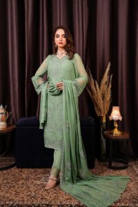 a woman in a green outfit standing in front of a curtain