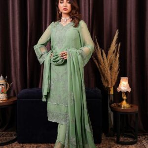 a woman in a green outfit standing in front of a curtain