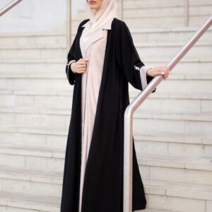 A woman in a black and white outfit is standing on a set of stairs