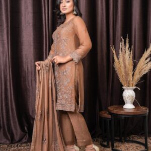a woman standing in front of a brown curtain